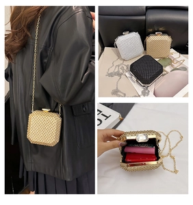 Dettaglio della pochette da sera glitterata in oro, bianco e nero con chiusura a gemma