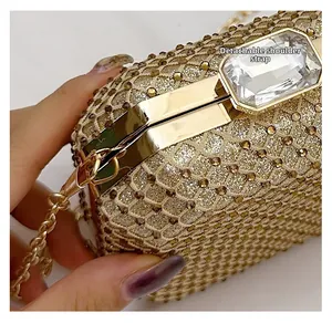 Dettaglio della borsa da sera con strass dorati, catena rimovibile e chiusura con gemma