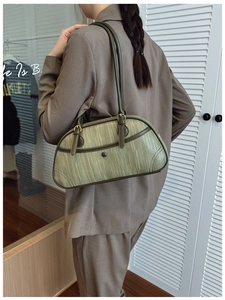 Detail of green woven texture shoulder bag with leather trim and sleek dual straps