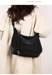 Detail of black matte leather hobo bag with thick knot strap and metal tassel accents