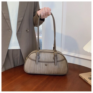 Detail of khaki woven texture handbag with golden buckle and sleek zipper closure
