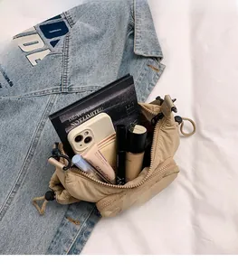 Spacious interior of khaki quilted crossbody bag with phone, notebook, and cosmetics