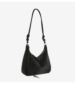 Detail of black Hobo bag with vintage texture, long strap knots, and tassel zipper