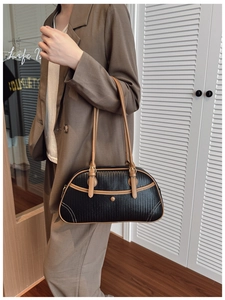 Vue latérale du sac porté épaule tissé avec bordure contrastée sur un mannequin chic