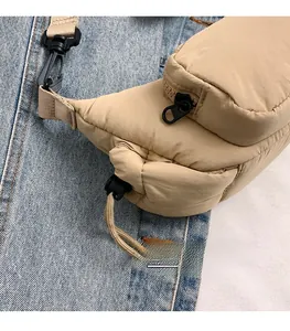 Detail of khaki quilted puffer crossbody bag featuring black zippers and matte buckles