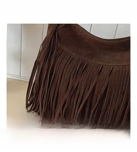 Détail du sac bandoulière en daim marron foncé avec de longues franges et des coutures fines