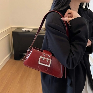 Deep red patent leather shoulder bag with oversized silver buckle in Y2K style