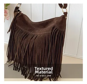 Gros plan sur le sac à franges en daim marron foncé avec anneau en métal doré