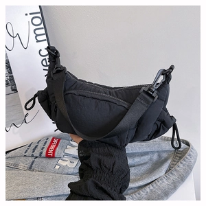 Close-up of black nylon quilted crossbody bag featuring ruched texture and adjustable drawstring