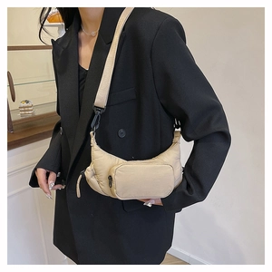 Detail of beige quilted nylon crossbody bag featuring a front pocket and textile strap