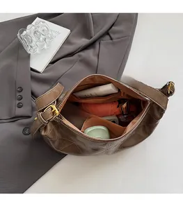 Top view showing large capacity interior of brown quilted shoulder bag with essentials