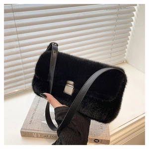 Détail du sac en fausse fourrure noire avec boucle en métal argenté et bandoulière en cuir