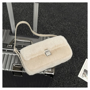 Détail du sac en peluche crème avec fermoir métallique argenté et bandoulière en cuir