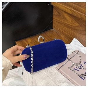 Detailed macro of royal blue velvet clutch featuring silver chain and rhinestone clasp