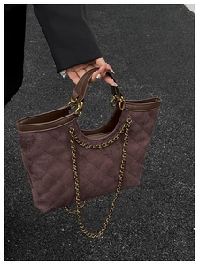 Detail of coffee brown quilted suede tote bag with chain strap and soft leather finish