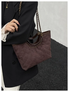 Détail d'un sac cabas en daim matelassé marron foncé avec bandoulière en chaîne dorée vintage