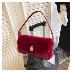 Détail d'un sac à bandoulière en fausse fourrure bordeaux avec boucle en métal argenté