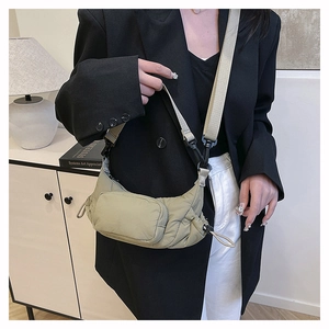 Close-up of olive green quilted shoulder bag with multi-pockets and adjustable strap