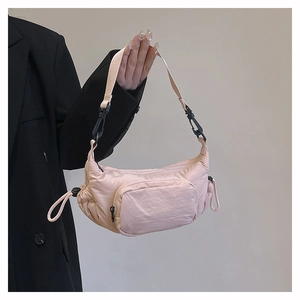 Detail of light pink nylon half-moon crossbody bag with functional drawstring and zipper