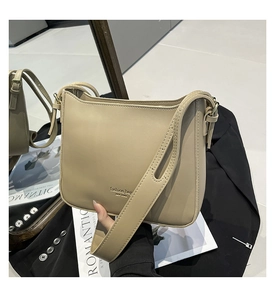 Détail du sac à bandoulière en cuir PU beige avec lettrage élégant et coutures fines