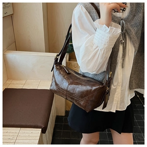 Close-up of quilted dark brown faux leather texture on minimalist crossbody bag