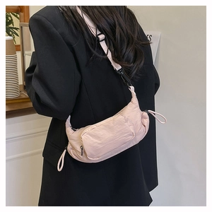 Detail view of pink canvas crossbody bag showing functional front zipper and adjustable strap
