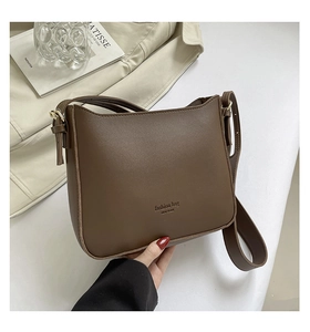 Vue détaillée du sac carré en cuir marron foncé avec texte New York doré