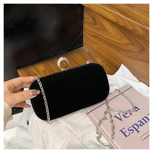 Detail of black velvet evening clutch with pebble shape and silver rhinestone ring clasp