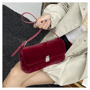 Détail du sac à bandoulière bordeaux en fausse fourrure avec fermoir argenté et cuir