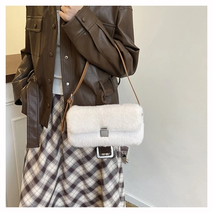 Détail d'un sac à bandoulière en peluche blanche avec boucle en métal et lanière brune