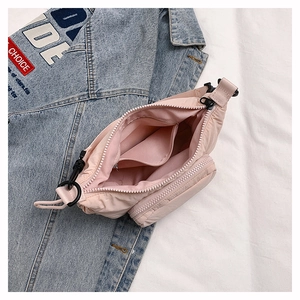 Detail of pink nylon bag interior featuring multiple zip pockets and black hardware