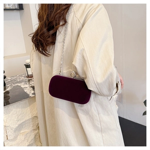 Detail view of purple velvet evening clutch with silver chain and rhinestone clasp