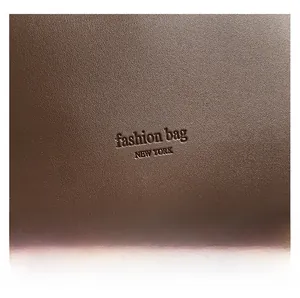 Gros plan sur la texture en cuir PU marron et l'inscription Fashion Bag New York du sac