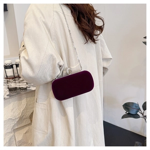Deep purple velvet clutch bag with silver chain and diamond-encrusted ring clasp detail