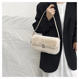 Détail d'un sac à bandoulière en fausse fourrure crème avec boucle en métal minimaliste
