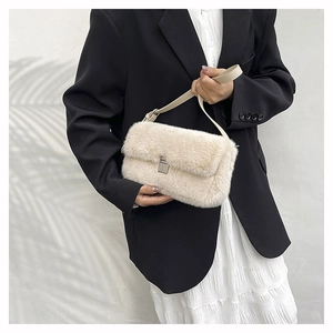 Détail du sac à épaule en peluche beige avec boucle en métal et bandoulière en cuir