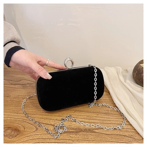Close-up of black velvet evening clutch bag with sparkling diamond-encrusted ring clasp