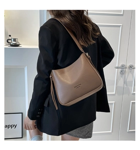 Vue latérale d'un sac bandoulière marron en similicuir avec texte New York porté