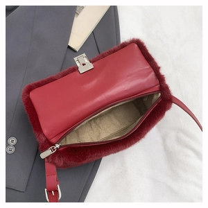Détail d'un sac à bandoulière en peluche rouge avec sangle en cuir et boucle métal