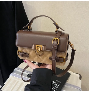 Detail von Farblock-Nähten und goldener U-Schnalle an einer Vintage-Umhängetasche