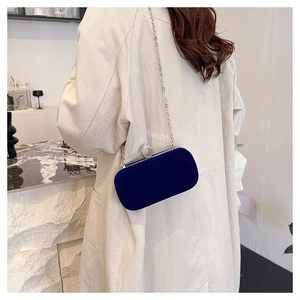 Detailed view of luxury navy velvet evening clutch with silver chain and rhinestone clasp