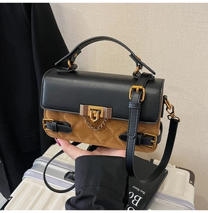 Detail der Kontrast-Patchwork-Tasche mit goldenen Beschlägen und Vintage-Schloss-Dekor