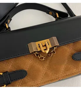 Detail der Tasche im Color-Block-Design mit gestepptem Wildleder und Goldverschluss