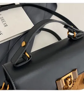 Detail der Tasche mit Farblock-Leder, brauner Steppung und goldenem Metallverschluss
