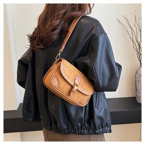 Detailansicht einer kamelfarbenen Wildleder-Baguette-Tasche mit Metallschnalle und Leder