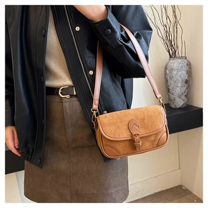 Nahaufnahme der braunen Wildleder-Baguette-Tasche mit Lederbesatz und Goldschnalle
