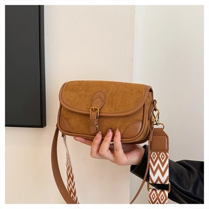 Detail der braunen Wildleder Baguette Tasche mit breitem Gurt und Metallschnalle