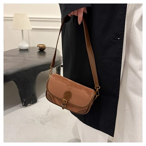 Detailaufnahme einer braunen Vintage-Baguette-Tasche aus Mattleder mit goldener Metallschnalle