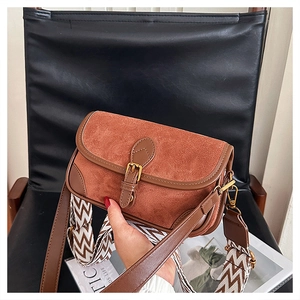 Detailansicht der braunen Wildleder-Baguette-Tasche mit Schnalle und breitem Gurt
