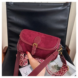 Details der burgunderroten Leder-Baguette-Tasche mit Retroschnalle und Web-Schultergurt